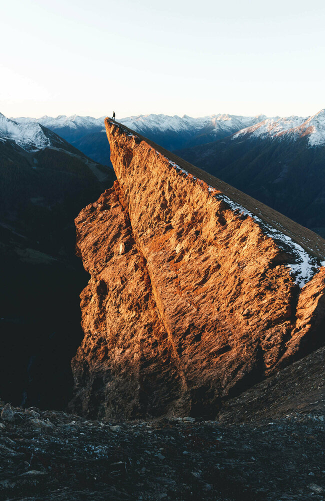 Bretterwand, also ein Berg, wird von der Sonne schön beleuchtet. Der erste Schnee ist schon gefallen und noch Schneereste liegen auf den umliegenden Berggipfeln.