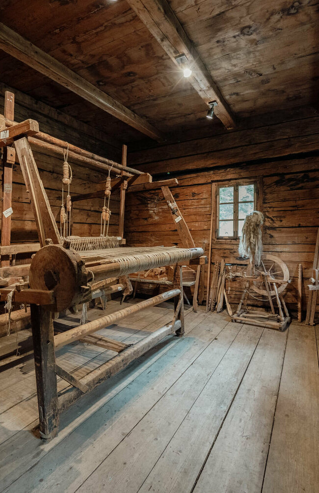 Weberei im Gerätemuseum Freilichtmuseum Alpines Leben Historischer Webstuhl sowie ein Spinnrad im Gerätemuseum des Freilichtmuseum "Alpines Leben" in Innervillgraten