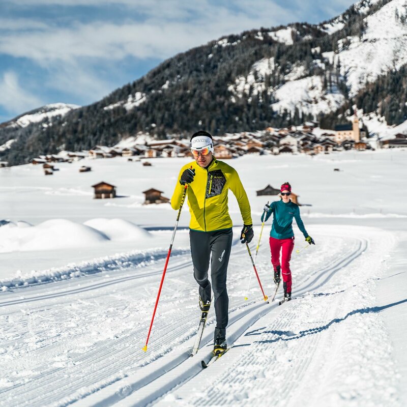 Langlaufen in den Tilliacher Feldern mit dem Dorf im Hintergrund