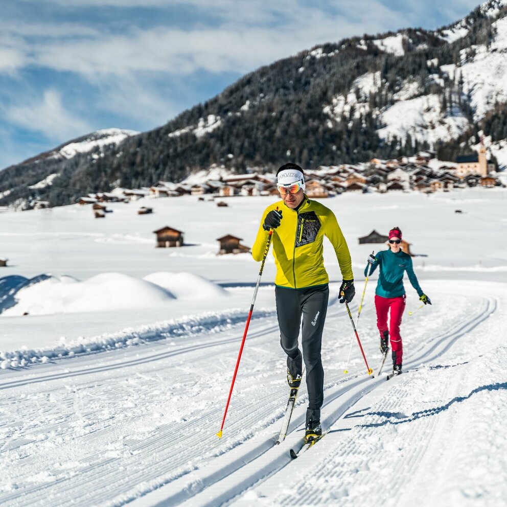 Langlaufen in den Tilliacher Feldern mit dem Dorf im Hintergrund