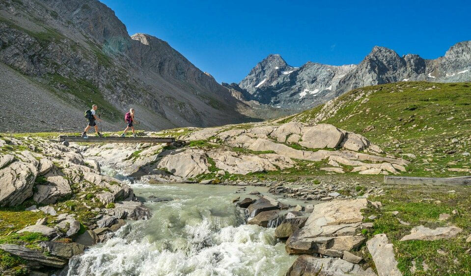 Leiterbach mit Großglockner Weitwanderer überqueren Bach im oberen Leitertal mit Blick auf den Großglockner, Etappe 4 der Glocknerkrone in Osttirol.