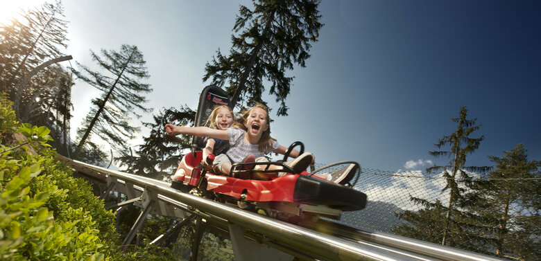 Zwei Mädchen genießen die spektakuläre Abfahrt mit dem Osttirodler vom Hochstein
