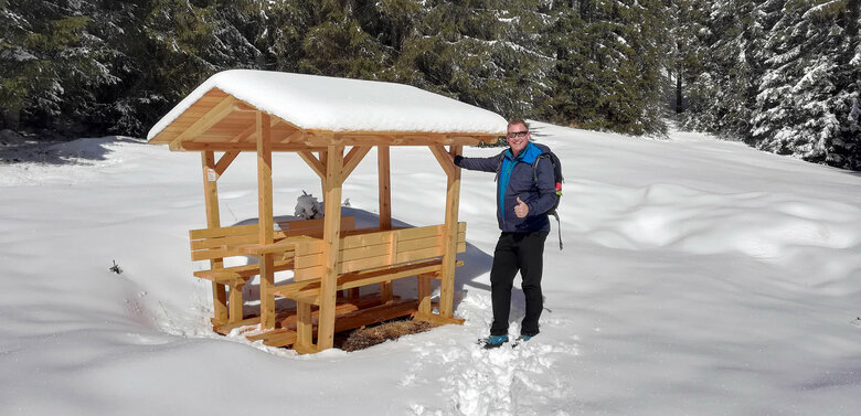 Lachender Mann fühlt sich wohl am Ruheplatz im Winterwanderdorf Kartitsch