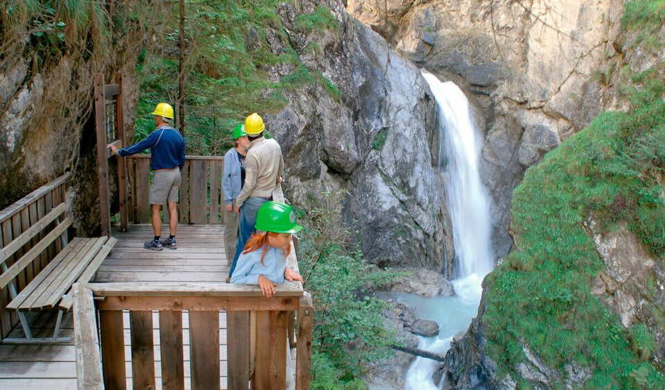 Aussichtskanzel Vier Personen stehen fasziniert auf der Aussichtskanzel des Wasserschaupfades und beobachten das tosend herabschießende Wasser in der Schlucht.