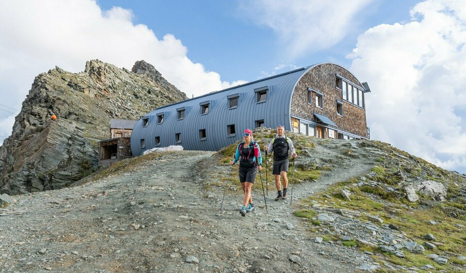 Stüdlhütte Zwei Weitwanderer vor der Stüdlhütte auf Etappe 3 der Glocknerkrone in Kals am Großglockner, Osttirol.