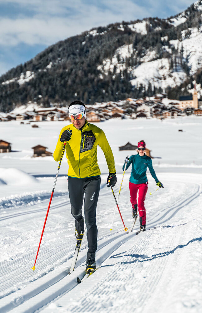 Langlaufen in den Tilliacher Feldern mit dem Dorf im Hintergrund
