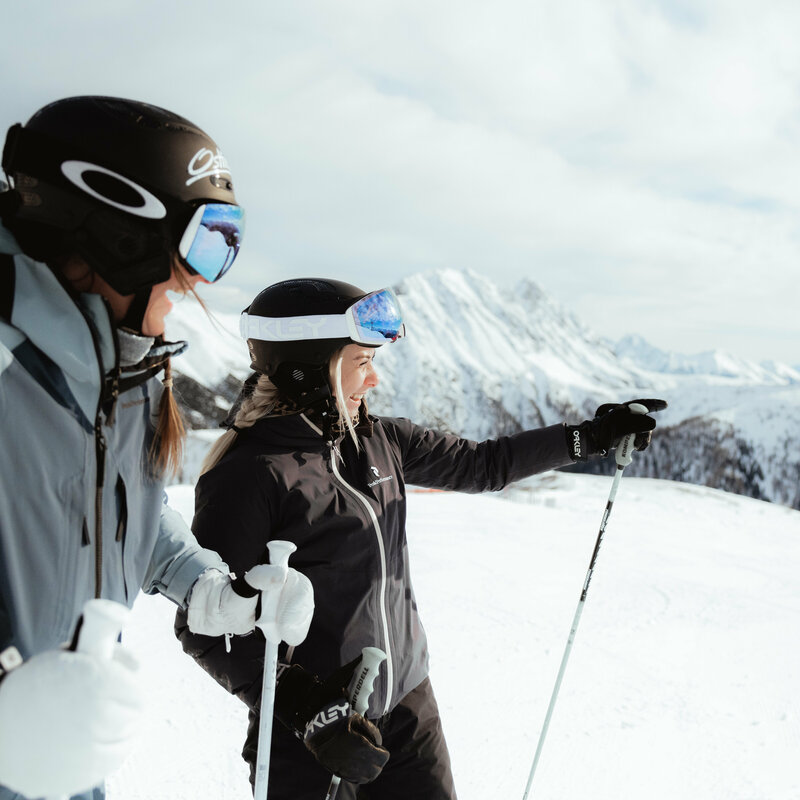 Skifahren in Obertilliach Frau zeigt in die Ferne - Skifahren in Obertilliach