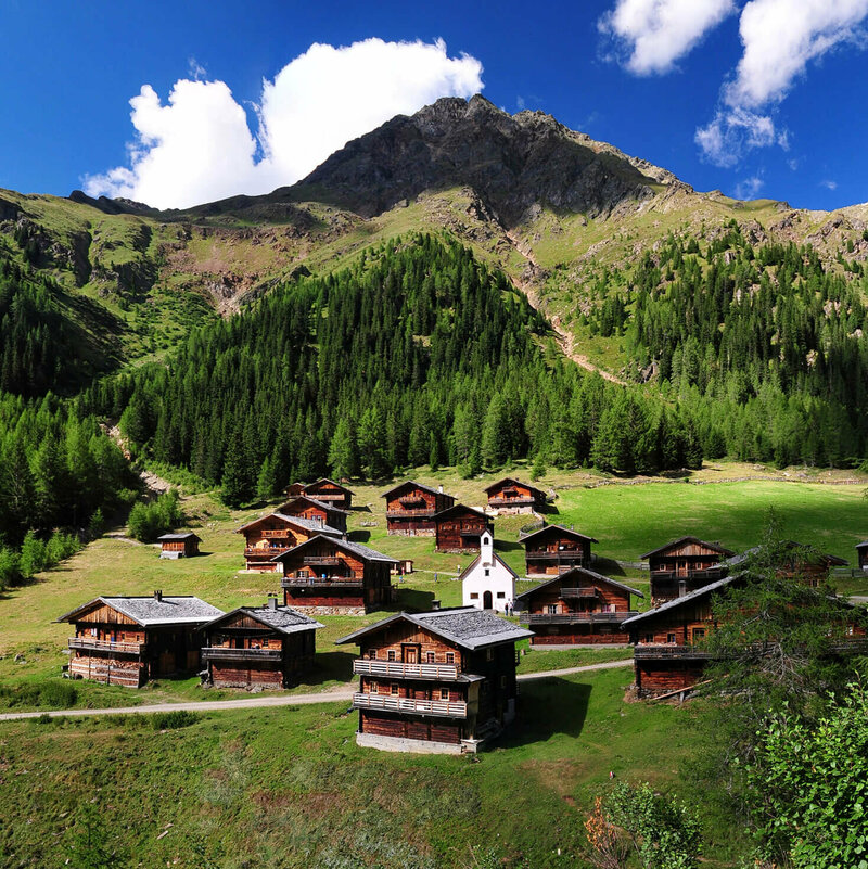 Das Almdorf Oberstaller im Villgratental umringt von Wiesen, Wäldern und Bergen