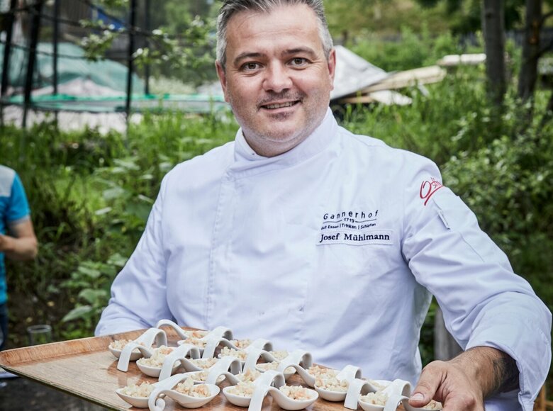 Josef Mühlmann vom Gannerhof Josef Mühlmann vom Gannerhof präsentiert auf einem Tableau in seinen Hände die von ihm zubereiteten und angerichteten Gerichte auf weißen Löffeln.