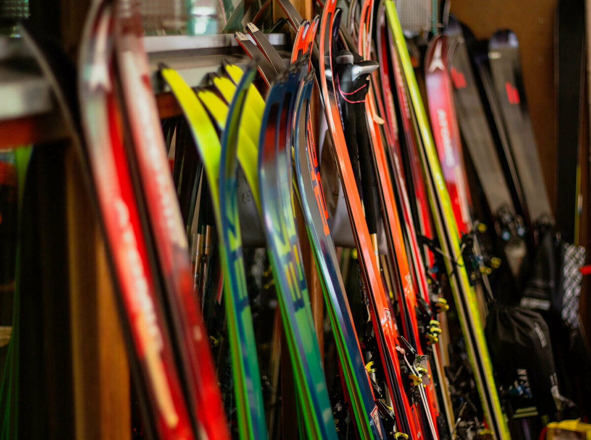 Verschiedene Ski stehen nebeneinander angelehnt an einen Ständer.