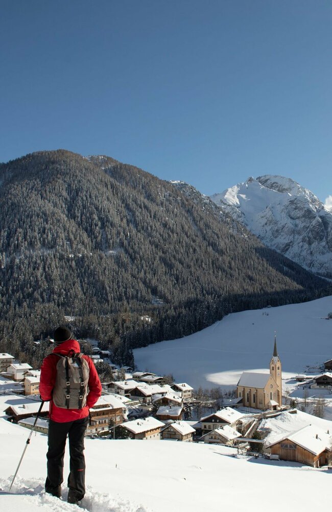 Winterwandern mit Aussicht Zwei Personen genießen beim Winterwandern den Ausblick auf das Dorf Kartitsch.