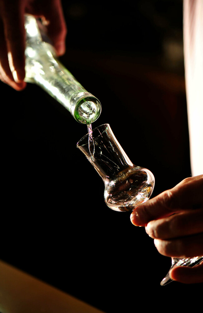 Osttiroler Pregler Osttiroler Pregler wird aus der Flasche in ein Schnapsglas eingeschenkt.