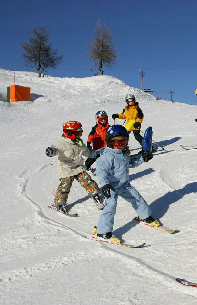 Skilehrerin mit Skikurs auf der Piste im Skizentrum Sillian im Hochpustertal.