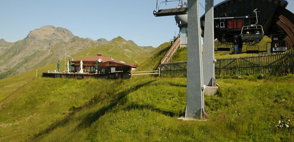 Steinermandl Panorama Zettersfeld „Ankunft an der Bergstation am Zettersfeld: Links das Berggasthaus Steinermandl, dahinter erhebt sich eindrucksvoll der Gipfel der Schleinitz.