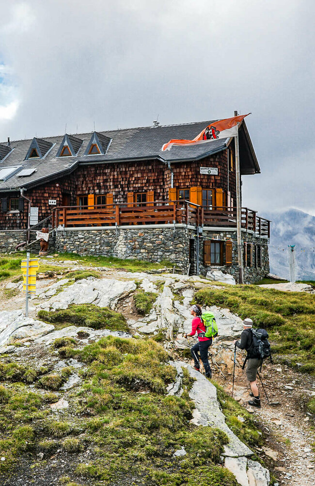 Badener Huette am Adlerweg Osttirol Etappe 4 Zwei Personen mit Wanderstöcken auf den letzten Metern vor der Badener Huette am Adlerweg in Osttirol.