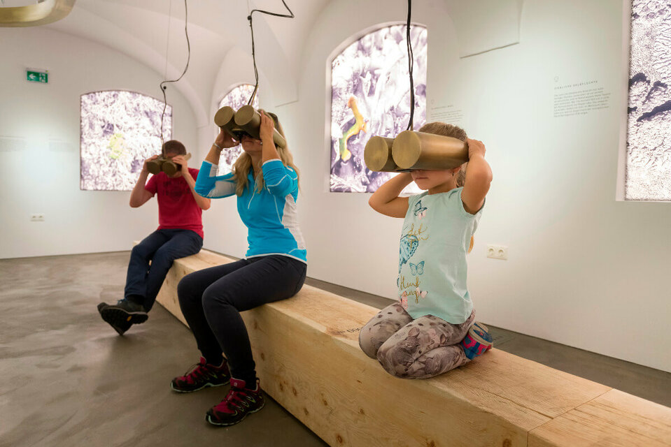 360 Grad Videos Eltern mit einem kleinem Mädchen sehen durch ein Fernglas im Nationaparkhaus in Matrei