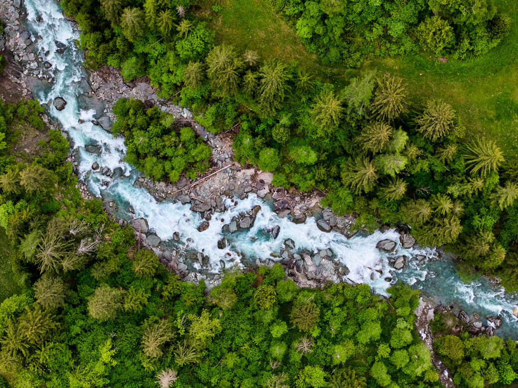 Aus der Vogelperspektive betrachtet, schlängelt sich der blaue Gletscherfluss Isel durch die grüne Umgebung Osttirols.