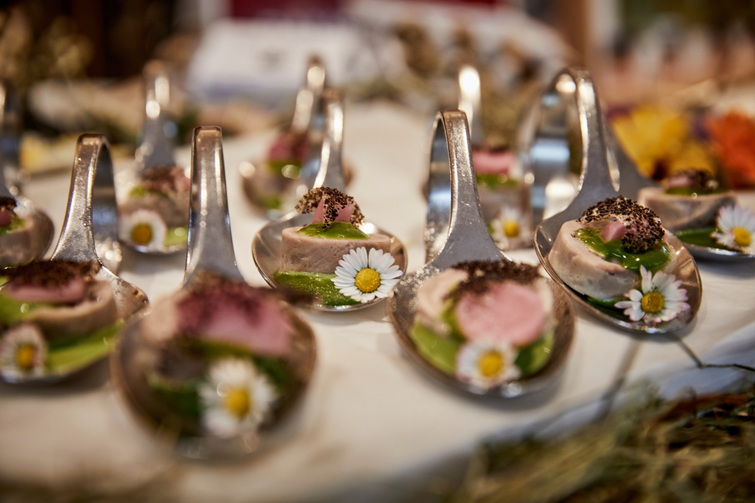 Haubenküche Gannerhof Haubenküche im Gannerhof - Gericht bestehend aus einem runden Fleischstück mit einer grünen Soße verziert mit einem Gänseblümchen auf einem Löffel angerichtet.